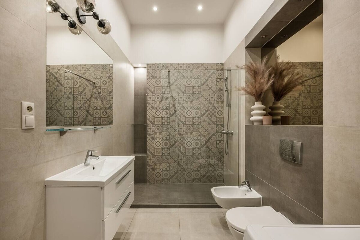 A modern bathroom with a shower, toilet, and sink.