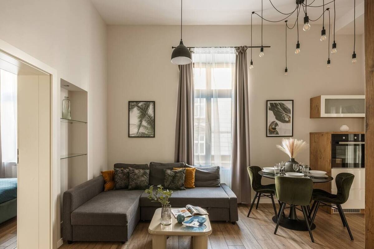 Ein modernes Wohnzimmer mit Sofa, Esstisch und Küchenzeile.