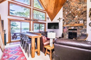 Ein gemütliches Wohnzimmer mit Kamin aus Stein, einem Holzesstisch und einer Ledersofa.