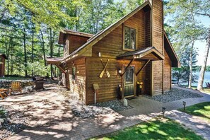 Eine Holzhütte mit Veranda und Grillplatz.