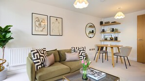 En stue med sofa, sofabord og et spiseområde med stole og bord.