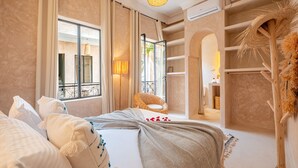 A hotel room with a bed, a wicker chair, a large window, and a built-in wardrobe. - Dar Shihab exclusive - breakfast included - swimming pool (Marrakech)