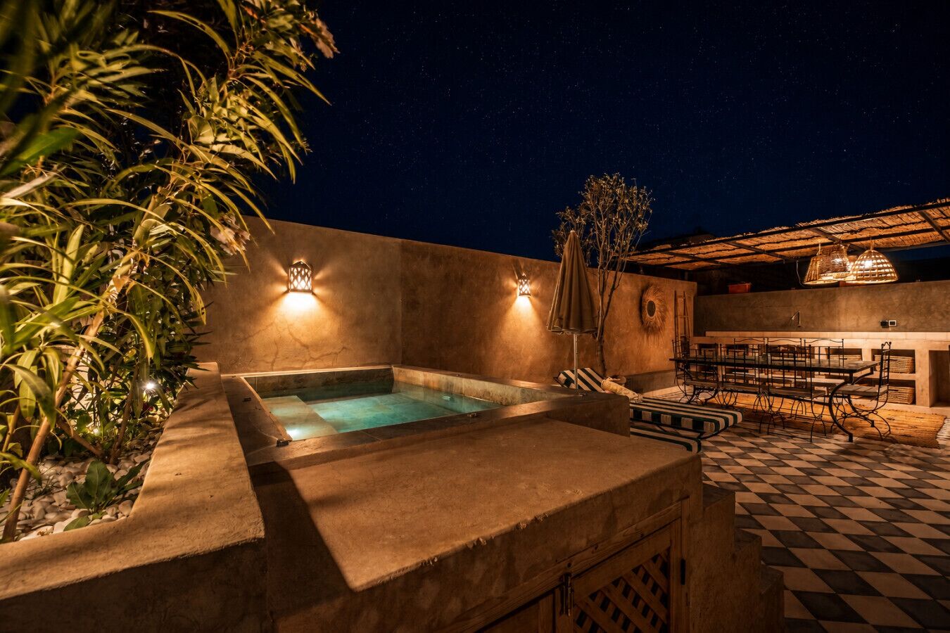 A rooftop pool area with a checkered floor, a hot tub, and outdoor seating.