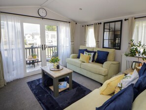 A living room with a sofa, a small table, and a potted plant. - Santa Maria (Llandysul)