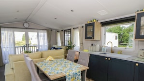 Ett kompakt bostadsutrymme med en soffa, ett matbord och ett litet kök.