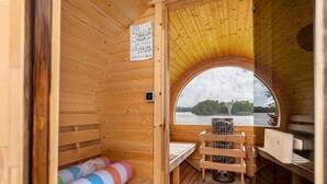 Puisesta laudelavasta, pöydästä ja järvinäkymästä koostuva sauna.