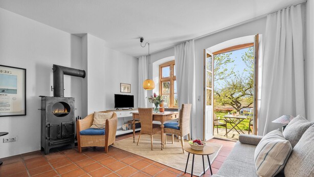 Una sala de estar con chimenea, comedor y vistas al jardín.