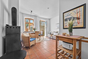 Una sala moderna con chimenea, comedor y ventanas amplias.