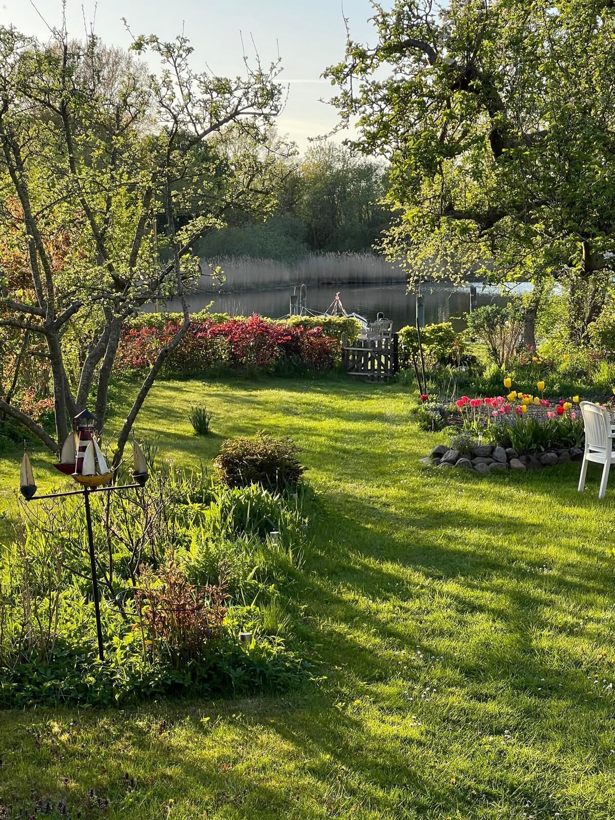 A well-maintained garden with a variety of plants and flowers, a small pond, and a gazebo.
