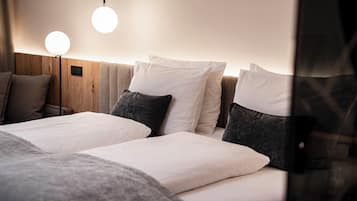 A hotel room with two beds, a wooden headboard, and two round wall lights.