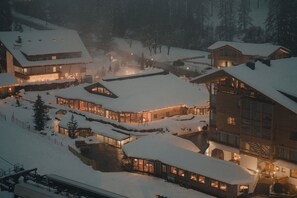 A snow-covered resort with multiple buildings, including a large lodge with a visible staircase and a smaller cabin. - Bad Moos Aqua Spa Resort (Sesto)