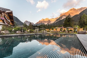 Una piscina con vistas despejadas a montañas al fondo.