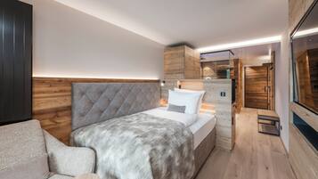 Ein modernes Schlafzimmer mit einem großen Bett, einer Couch, einem Holzkopfende und einem eingebauten Kleiderschrank.