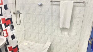 Ein Badezimmer mit Dusche, Handtuchhalter und Waschbecken.