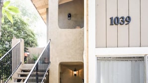 A building with a number '1039' on the facade, a staircase with a metal railing, and a small window with a light fixture. - Escondido Urban Stay - Stylish 2BR Apartment (Escondido)
