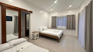 Habitación de hotel moderna con una cama grande, una mesita de noche, un espejo y vistas al exterior a través de una ventana.