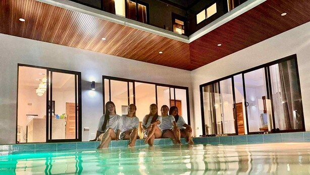 Un área de piscina interior moderna con amplias ventanas y techo de madera.