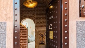 A hotel entrance with a metal door, a number plate, and a brick wall. - Riad Sultanes-Peaceful haven with private Jacuzzi (Marrakech)
