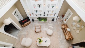 A spacious living area with a fireplace, a Netflix sign, and a variety of decorative items on shelves. - Riad Sultanes-Peaceful haven with private Jacuzzi (Marrakech)