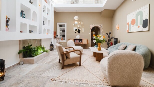 A spacious living area with a high ceiling, a fireplace, and a balcony with intricate railings. - Riad Sultanes-Peaceful haven with private Jacuzzi (Marrakech)