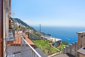 Une ville côtière avec des maisons à étages, une vue sur la mer et une église imposante située sur une colline.