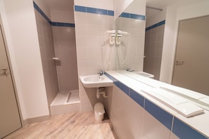A bathroom with a shower, sink, and toilet.