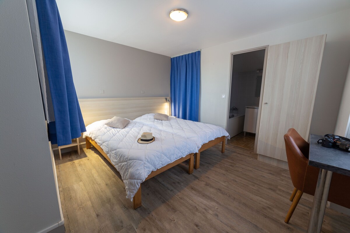 A room with a bed, a desk, and a chair.