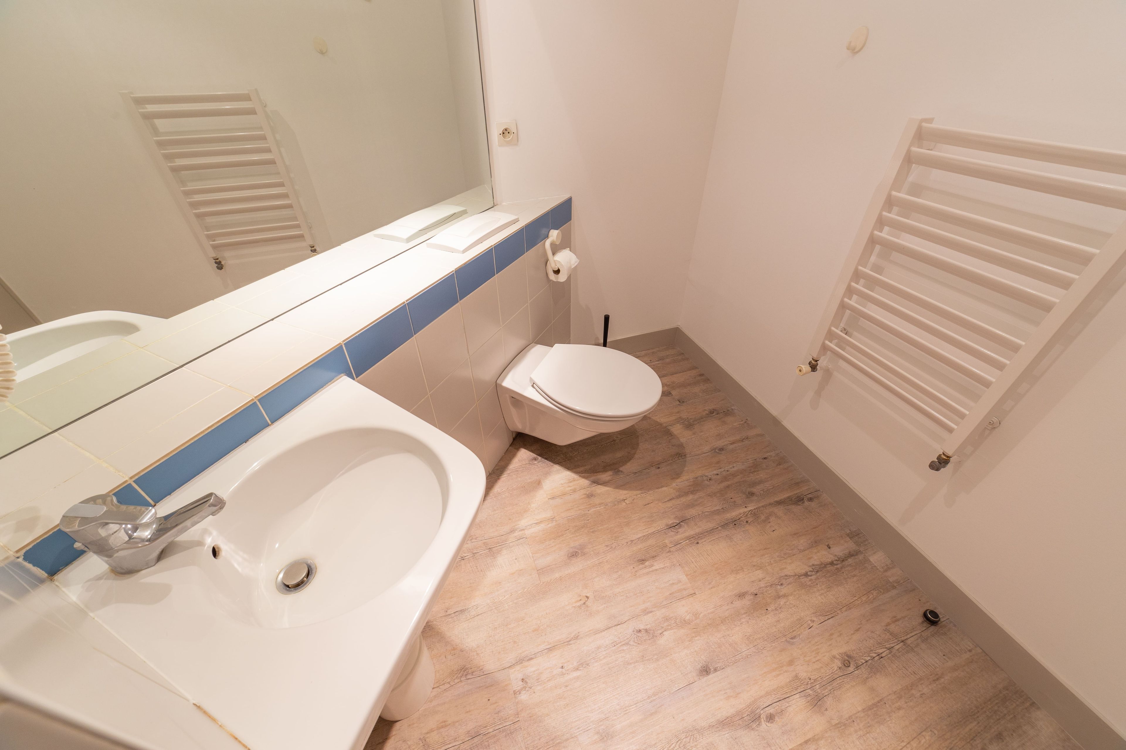 Ein Badezimmer mit Waschbecken, Toilette und Spiegel.