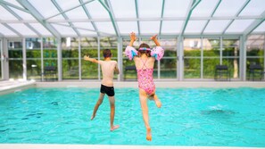 A swimming pool with a glass ceiling structure.