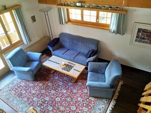 A cozy living room with a blue sofa, two armchairs, a coffee table, and a patterned rug. - Plaun Pazzola mit Garage Bösch, (Sedrun/Rueras), 684.01 by Interhome (Rueras Dieni)