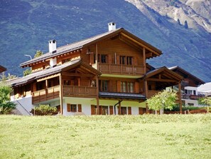 A multi-story wooden chalet with balconies, set against a mountainous backdrop. - Plaun Pazzola mit Garage Bösch, (Sedrun/Rueras), 684.01 by Interhome (Rueras Dieni)