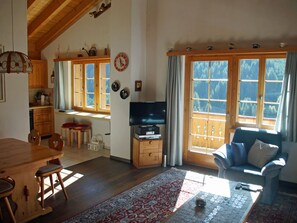 A cozy living room with a television, a sofa, and a dining area with chairs and a table. - Plaun Pazzola mit Garage Bösch, (Sedrun/Rueras), 684.01 by Interhome (Rueras Dieni)