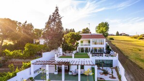 A modern house with a patio, a fenced garden, and a view of the surrounding countryside.