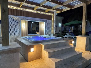 A hot tub with steps leading up to it, surrounded by wooden panels and stone steps. - Modern Studio Near Cabarete Beach Pool, Wi-Fi, Safe Area (Cabarete)