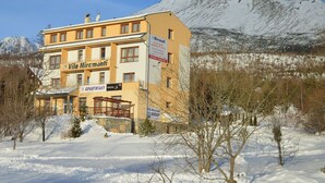 A yellow building with 'Vila Miramonti' signage, indicating it is an apartment hotel. - Miramonti Apartmany (Vysoké Tatry)