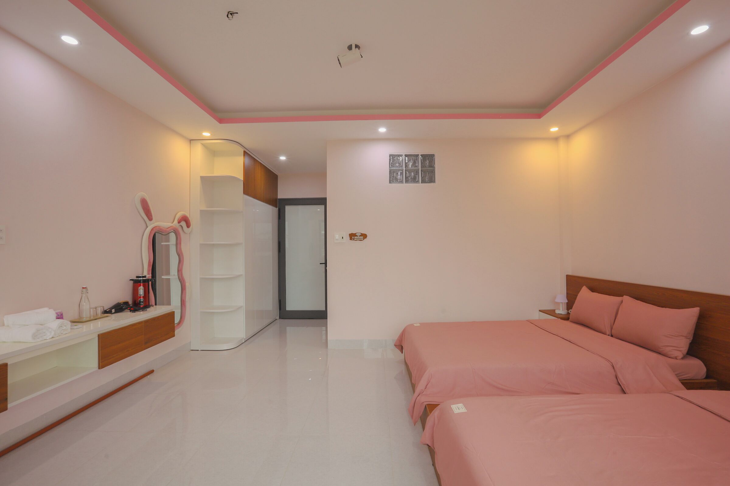 A bedroom with a bed, bedside table, and a mirror.