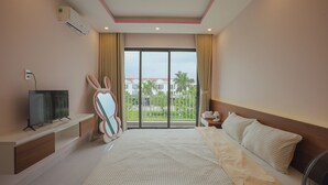 A hotel room with a bed, a TV, a mirror, a window with curtains, and a balcony view. - TRÀ HOMESTAY CS3 (Hue)