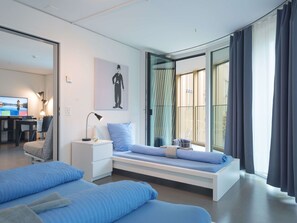 A modern bedroom with a bed, bedside table, and a view of the outdoors. - Apartment  by Interhome (Lucerne)
