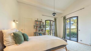Une chambre à coucher avec un lit, une bibliothèque, une fenêtre et une porte.