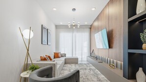 Ein modernes Wohnzimmer mit einer Couch, einem Couchtisch, einer Stehlampe und einem an der Wand befestigten Flachbildfernseher.
