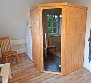 Une pièce d’angle avec une cloison en bois, une petite table, une chaise et une fenêtre.
