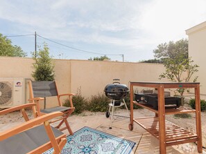 An outdoor patio with a grill, chairs, and a table. - Seafront Villa Adriatica with pool by Interhome (Pašman/Neviđane)