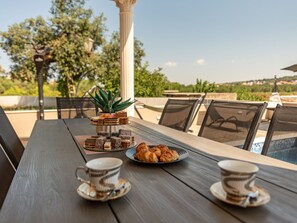 An outdoor dining area with a wooden table, chairs, and a view of a swimming pool. - Holiday Home Solea with pool by Interhome (Zadar/Bibinje)