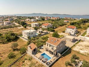 A residential area with modern houses, a swimming pool, and a view of the sea. - Holiday Home Solea with pool by Interhome (Zadar/Bibinje)