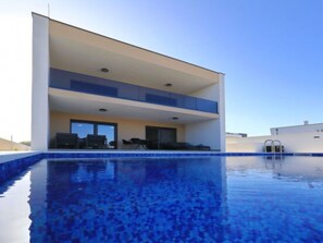 A modern two-story building with a swimming pool in front. - Villa Good Vibes with heated pool by Interhome (Vrsi)