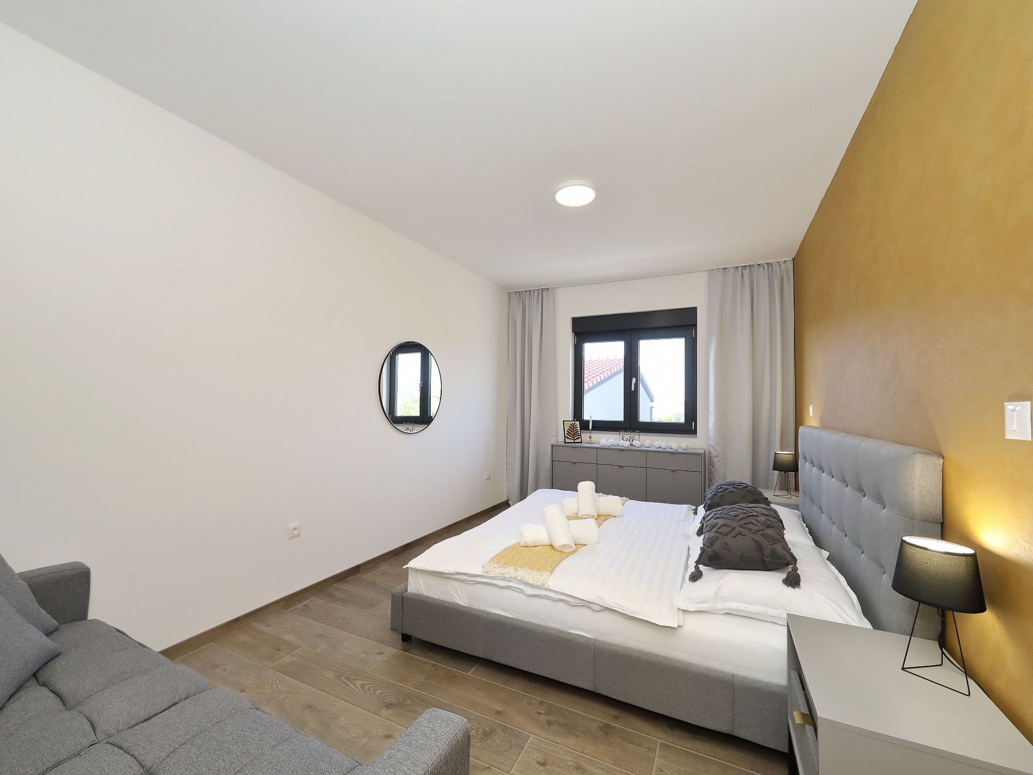 Une chambre à coucher moderne avec un lit, une table de chevet et une fenêtre.