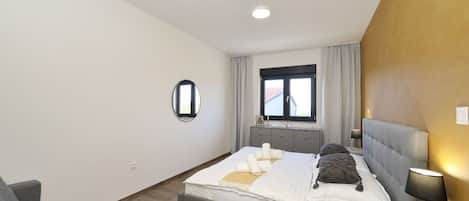 Une chambre à coucher moderne avec un lit, une table de chevet et une fenêtre.