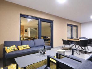 A modern living room with a sofa, coffee table, and dining area. - Villa Good Vibes with heated pool by Interhome (Vrsi)
