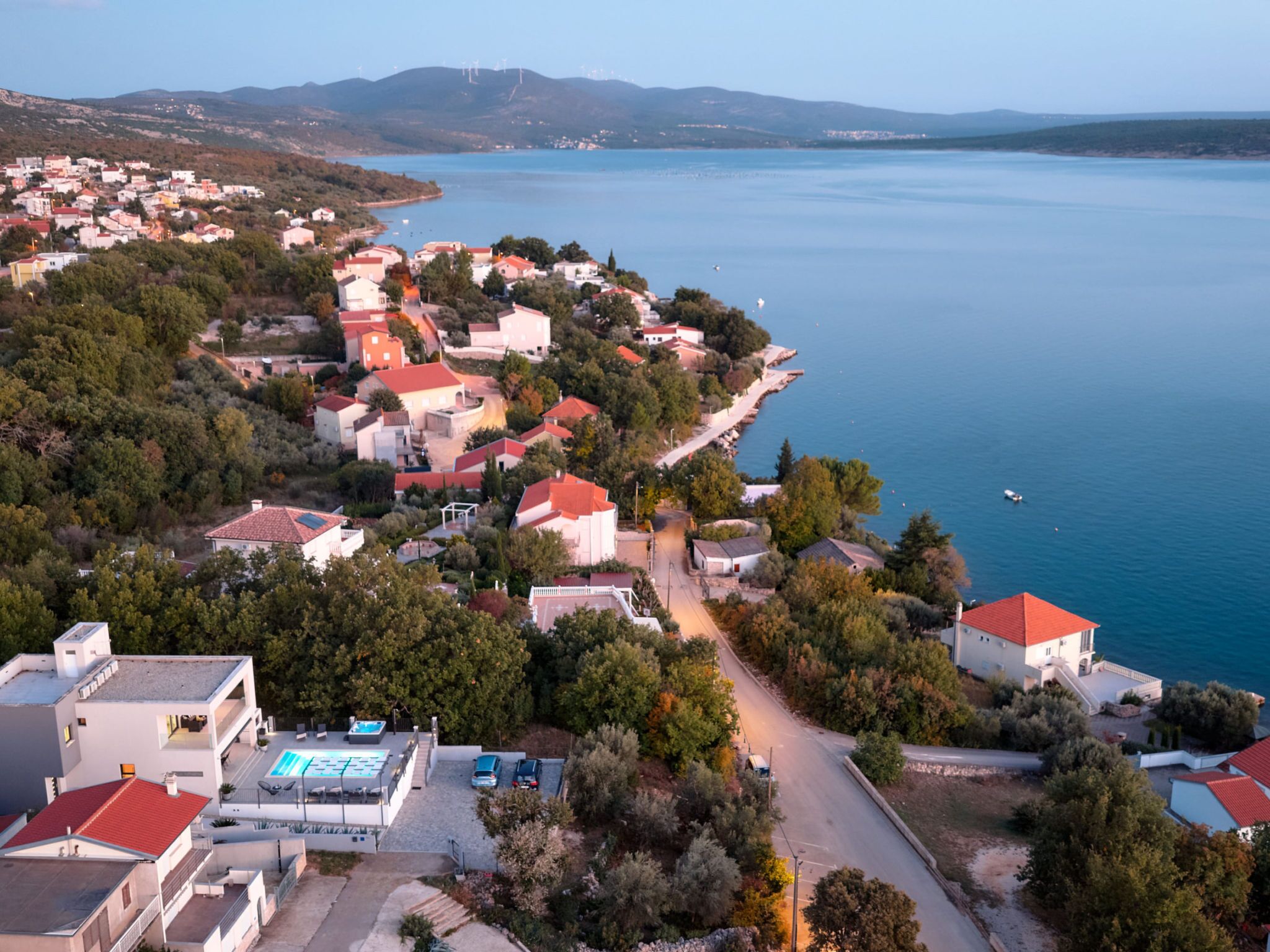 A coastal town with buildings along the waterfront, a clear sky, and a calm sea.