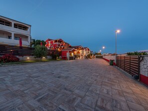 A paved walkway leading to a building with multiple balconies and a red facade. - Vacation home  by Interhome (Donje Rastane)